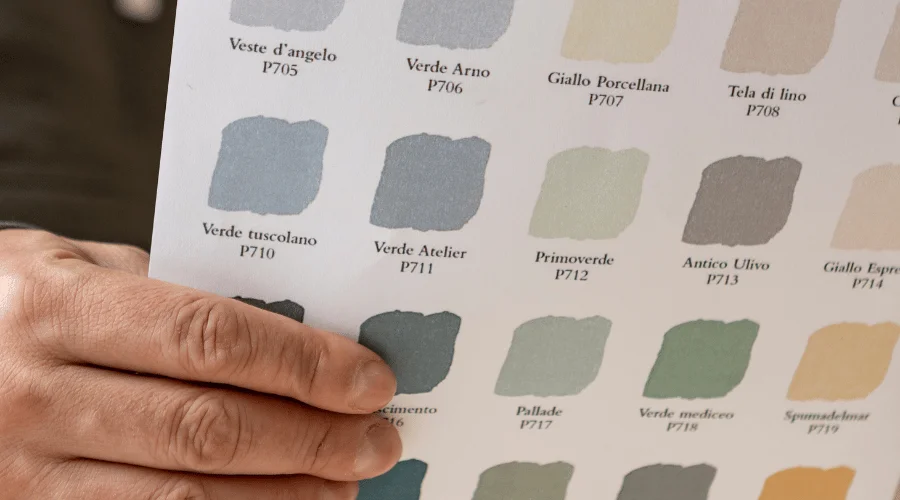 hand holding a sheet of paint color swatches