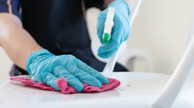 person spraying a cleaner and wiping an area clean